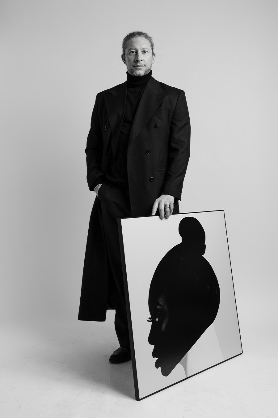 FX Pelissier standing with a framed artwork